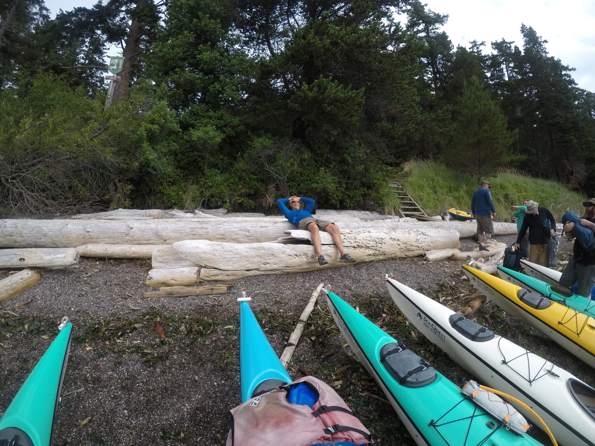 Sea kayaks pulled onto a remote beach during a multi-day kayak camping tour in the San Juan Islands, Washington