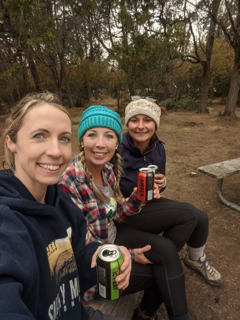 Three women enjoying drinks outdoors.